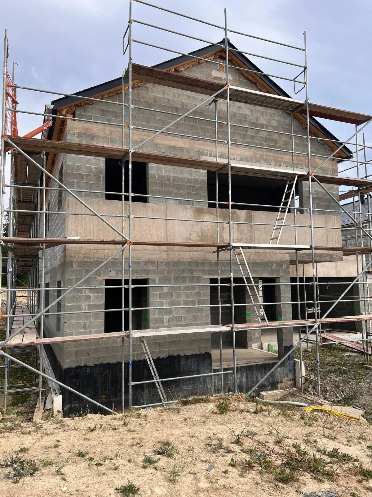 Maison en construction, murs en blocs sous échafaudage